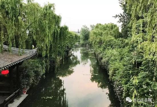 城里居民筑台而居,房上挂起的串串红灯笼,水中石桥的倒影,从后院抻出来的垂柳……好一个“不是江南水乡,胜似江南水乡”!